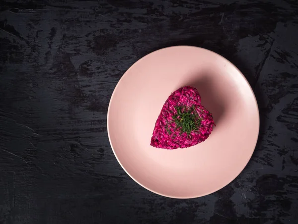 Valentijnsdag feestelijk diner. Bietenwortelsalade met kropom op een roze bord — Stockfoto