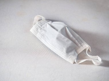 Beyaz arka planda enfeksiyon ve soğuk algınlıklarını önlemek için tek kullanımlık koruyucu maske