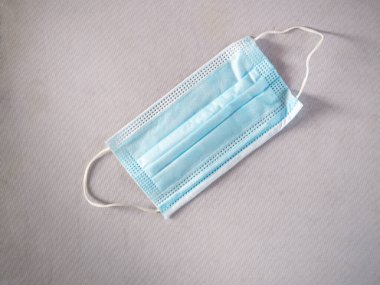 Beyaz arka plandaki enfeksiyon ve enfeksiyonları önlemek için mavi kullan-at koruyucu maske.