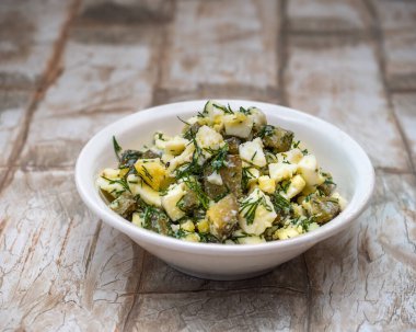 Yumurta ve turşudan oluşan basit bir diyet salatası. Bitkiler ve baharatlarla birlikte. Yoğurtla kaplanmış.