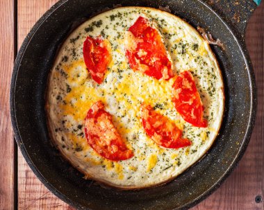 Domatesli omlet ve peynirli kızartma tavası manzaralı yakın çekim.