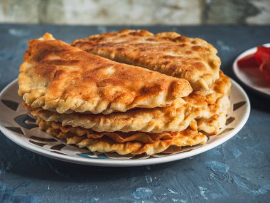 Seramik tabaktaki sıcak ev yapımı börekler. Gri arka planda yakın plan.