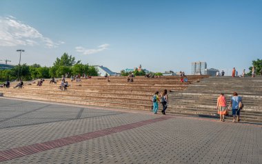 Bahar şehri resmi, oturanlarla uzun merdivenler, mavi gökyüzü güneşli bir gün.