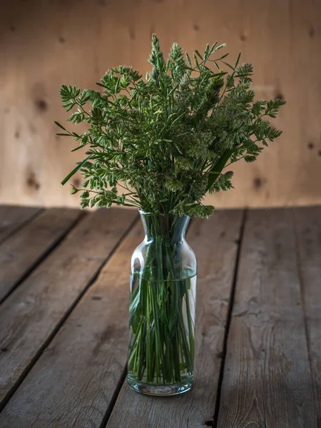 Bouquet of eared wild herbs in a tall glass vase — Stock Photo, Image