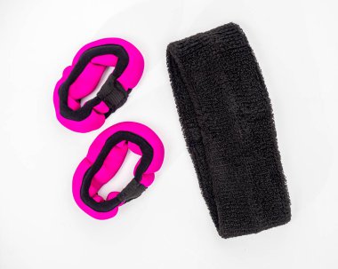 Spor aktiviteleri için bir aksesuar seti. El askısı ve beyaz arka planda saç bandajı.