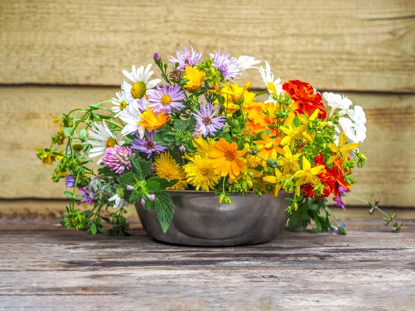 Ein bunter Strauß sommerlicher Wildblumen in einer Metallschale in Großaufnahme — Stockfoto