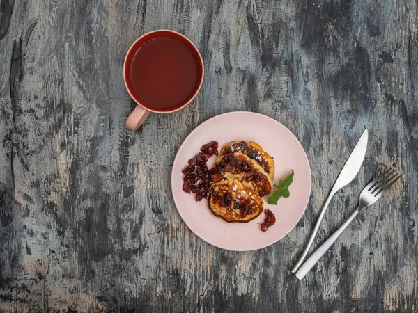 Elma dolgulu gözleme ve elma reçelli çay, pembe seramik tabaklar ve gri arka planda çatal bıçak takımı.