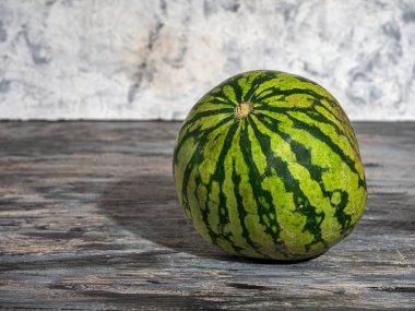 Çizgili karpuz gri arka planda yatay yakın planda kesilmemiş.