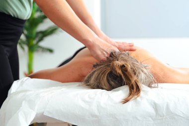 Tanımlanamayan bir kadın terapist masaj masasında yatan bir hastaya profesyonel bacak masajı yapıyor. Spa ortamında dolaşım gelişimi ve tedavi amaçlı kas gerilimi tedavisi. 