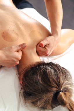 Yakın plan kadın terapist masaj masasında yatan bir hastaya profesyonel bir bacak masajı yapıyor. Spa ortamında dolaşım gelişimi ve tedavi amaçlı kas gerilimi tedavisi. 