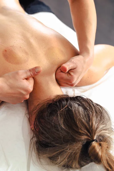 Yakın plan kadın terapist masaj masasında yatan bir hastaya profesyonel bir bacak masajı yapıyor. Spa ortamında dolaşım gelişimi ve tedavi amaçlı kas gerilimi tedavisi. 