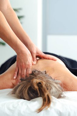 Tanımlanamayan bir kadın terapist masaj masasında yatan bir hastaya profesyonel bacak masajı yapıyor. Spa ortamında dolaşım gelişimi ve tedavi amaçlı kas gerilimi tedavisi. 