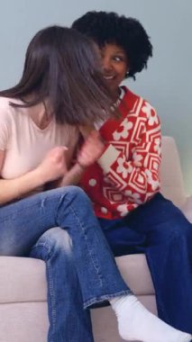 Üniversite sınavlarını, mutluluk konseptini, başarı, arkadaşlık, çeşitlilik, eğitim, duygu, neşe ve pozitif enerji kavramını geçtikten sonra başarıyı kutlayan iki çok ırklı kadın arkadaş kanepede oturuyor..