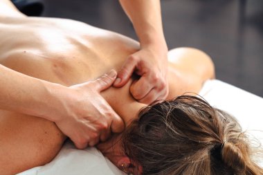 Yakın plan kadın terapist masaj masasında yatan bir hastaya profesyonel bir bacak masajı yapıyor. Spa ortamında dolaşım gelişimi ve tedavi amaçlı kas gerilimi tedavisi. 