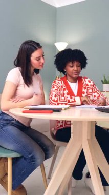 Kitaplar ve tablet, eğitim konsepti, öğrenim, takım çalışması, çeşitlilik, arkadaşlık, konsantrasyon, akademik ve başarı gibi konularda birlikte eğitim gören iki çok ırklı kız öğrenci..