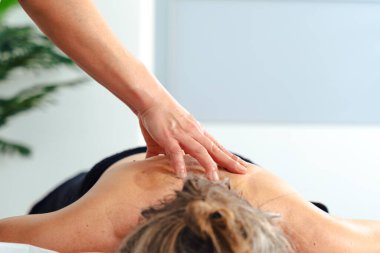 Tanımlanamayan bir kadın terapist masaj masasında yatan bir hastaya profesyonel bacak masajı yapıyor. Spa ortamında dolaşım gelişimi ve tedavi amaçlı kas gerilimi tedavisi. 