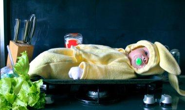 Eğlenmek için bir fırın tepsisindeki ocakta tavşan kostümünü küçük çocuk yatıyor