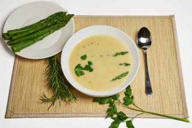 Ön planda bir kase kuşkonmaz çorbası, arka planda kırsal dekor ve fotokopi alanı olan yüksek stüdyo fotoğrafları.