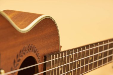 Ukulele, dört telli Hawaii kökenli küçük bir gitar, ön planda bej arka planda fotokopi alanı var..