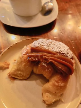 Arjantin kahvaltısı, yanında sütlü kahveyle birlikte sütle doldurulmuş hilal şeklinde bir rulo..