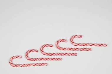 Kırmızı ve beyaz çizgili bastonlar beyaz arkaplanda kopyalama alanı ile şekiller oluşturur..