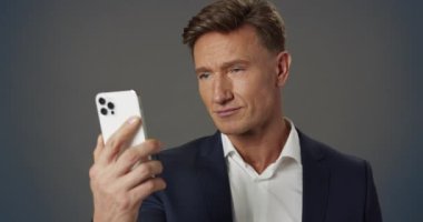 Yakışıklı Başarılı Profesyonel İş Adamı Akıllı Telefon Kullanıyor Ekran Yavaş Harekete Bakıyor. Kendine güvenen lider pozu. Yakından bakınca Yetişkin Erkek Yönetici Portresi. Modern İş Teknolojisi Konsepti.