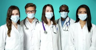 Doktorlar içeride tıbbi maske takıyor. Güzel Uluslararası Sağlık Hizmetleri Genç Tıp Ekibi Saygıdeğer. Profesyonel Başarı Sağlıkçıları Grubu Ağır Çekimde Gülümseyen Beyaz Önlüklü Pozisyon