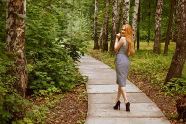 Kız parkta yol boyunca yürüyüş etrafında döndü