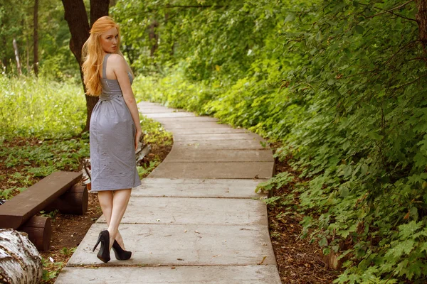 Menina em vestido de negócios andando no jardim — Fotografia de Stock