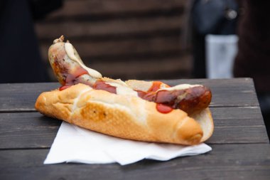 Ahşap arka planda bir sosislinin yakın çekimi. Alman sosisi, doğal, organik olarak yetişmiş etten yapılır. Lezzet ahşap bir masada yatıyor. Açık havada hazırlandı..