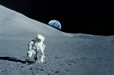 Astronot Ay 'da yürüyor. Ufukta kara görünüyor. Bu görüntünün elementleri NASA tarafından döşendi.. 