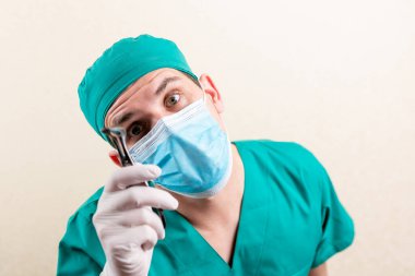 Doktor ENT, elinde bir cihazla maske ve gözlük takıyor. Yüksek kalite fotoğraf