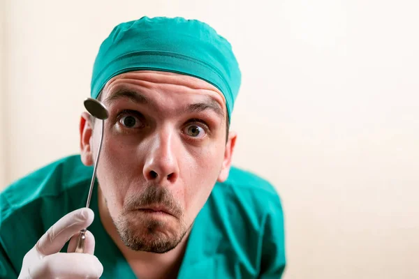 Doctor ENT, wearing a mask and glasses, with a device in his hands. — Stock Photo, Image