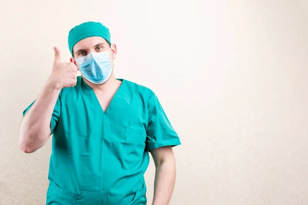 Doctor in mask and cap, showing thumbs up. — Stock Photo, Image