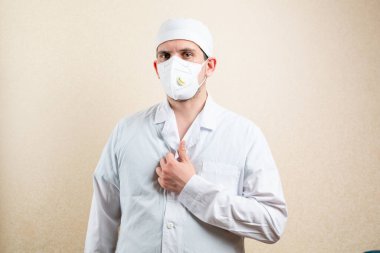 Maskeli ve şapkalı doktor, baş parmağını kaldırıyor..