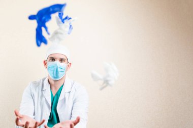 Doktor oynuyor ve eldivenlerini çıkarıyor. Hafif bir arkaplanda.