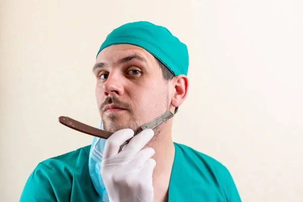 Funny doctor with a straight razor in his hands. — Stock Photo, Image