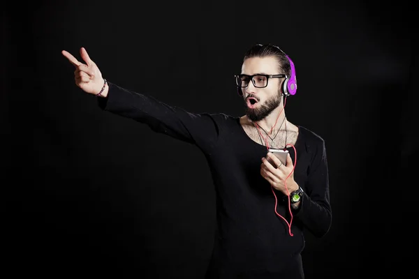 Cara elegante com fones de ouvido roxos no estúdio — Fotografia de Stock