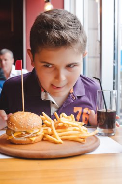 komik küçük çocuk gıda kavramı bir kafede hamburger yemek