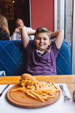 komik küçük çocuk bir kafede hamburger yemek