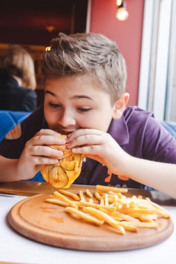 komik küçük çocuk bir kafede hamburger yemek
