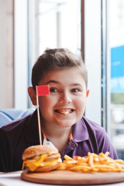 komik küçük çocuk bir kafede hamburger yemek