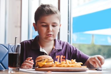 komik küçük çocuk bir kafede hamburger yemek