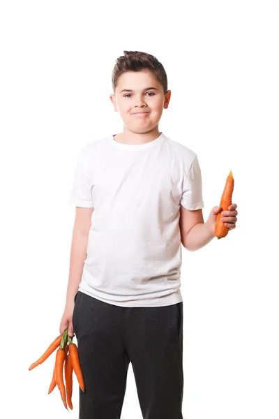 Funny boy showing a carrot on a white background in the studio, — Stock Photo, Image