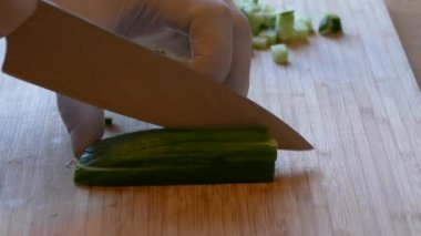 Salatalık doğrayan kadın. Kadın elleri yeşil salatalık halkalarını kesti..