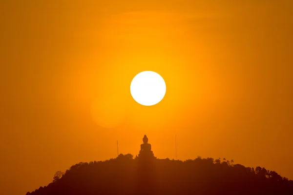 stock image ound red sun above big Buddha