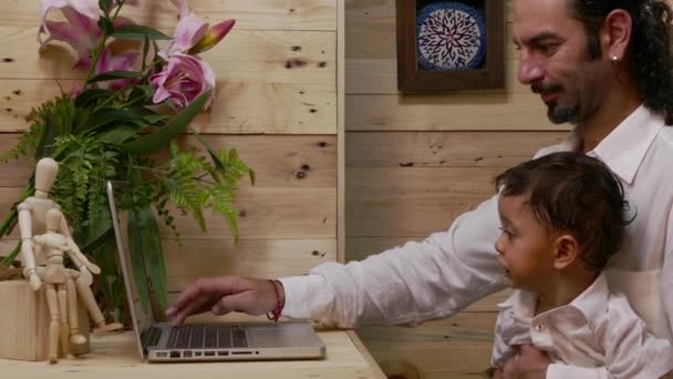 Vater unterrichtet seinen Sohn am Laptop — Stockvideo