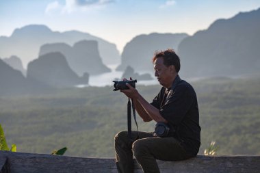 Bir fotoğrafçı, sabahları güzel manzaraların fotoğraflarını çekmek için bir kamera hazırlar..