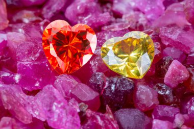 Kırmızı ve sarı kalp şeklinde mücevherler doğal kırmızı taşın üzerine konur. Kalp şeklinde mücevherler sevgililer günü için çok güzel hediyelerdir.