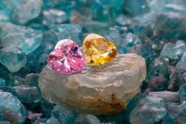 Pembe ve sarı kalpler ham mor ametist taşların üzerine işlenir. Ham gökyüzünün ortasında mavi değerli taşlar..